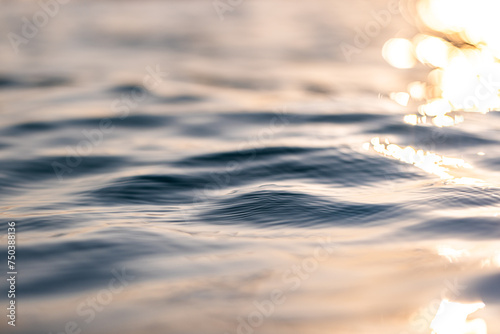 Beautiful closeup sea water surface. Sunset sunrise gold blue colors calm soft waves relaxing horizon. Dream fantasy shallow focus, blur seascape sky. Tranquil peaceful nature pattern, Mediterranean 