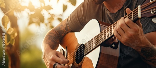 Passionate musician strumming acoustic guitar outdoors with focus on hands and instrument