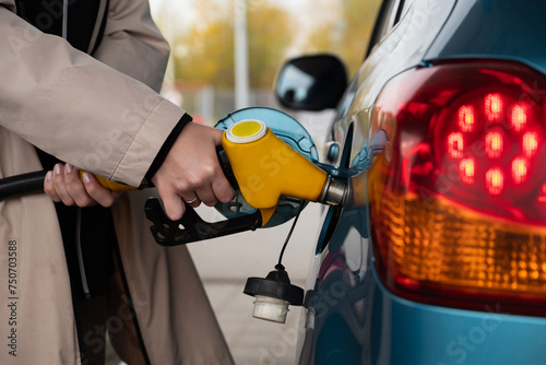 Pumping gas at the gas pump. The woman refuels the car. A woman at a gas station. A woman refuels a car with gasoline at a gas station. Fuel injection 