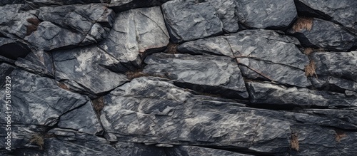 A black and white close-up shot of large granite rocks, showcasing their texture and details. The rocks appear rugged and massive, dominating the frame with their imposing presence.