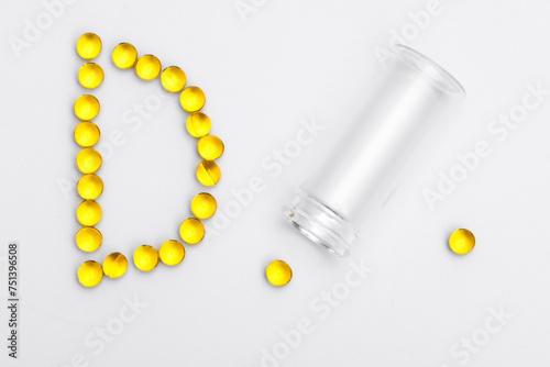 Żółte małe kapsułki z witamina d, suplement diety