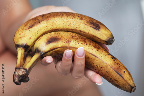 Ripe banana brown skin. Bunch of over riped bananas. Food waste background. Food scraps use. Healthy smoothie preparation. Rotten brown bananas. Woman hand holding fruits.