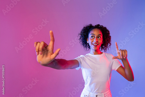 Enthusiastic black woman gestures at an invisible screen, neon background