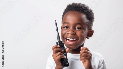 African-American little boy happily playing, talking with a toy walkie-talkie radio on a white background