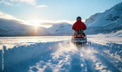 An adventurous person snowmobiling through a vast, snow-covered mountains