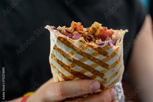 Kebab lawasz w tortilli z bliska, pyszny gorący posiłek w dloniach