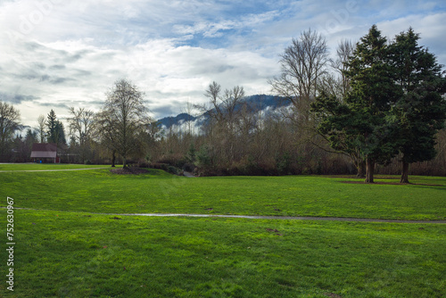 2024-02-20 CONFLUENCE PARK IN ISSAQUAH WASHINGTON WITH LUSH GREEN GRASS AND TREES WITH A CLOUDY SKY