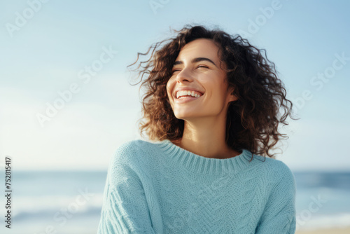 Joyful woman enjoying sunshine on sandy beach. Emotional wellbeing and relaxation.