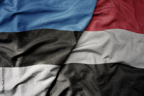 big waving national colorful flag of yemen and national flag of estonia.