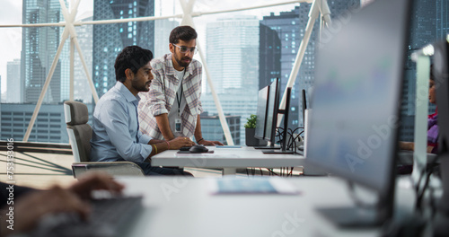 Two Indian Colleagues Having a Conversation While Busy Working on a Business Project. Software Engineer Talking with Project Manager During a Meeting. Teamwork in a Modern Corporate Office