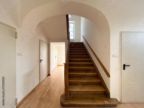Dębowa balustrada i schody w starej, eleganckiej przedwojennej willi. Łuk nad schodami.