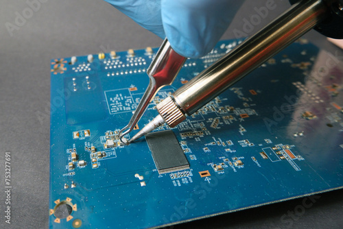 Working on surface mount device with soldering iron. Printed circuit board repairing. Smt components on electronic card.