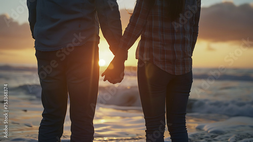 Casal feliz na praia ao pôr do sol de mãos dadas contemplando o oceano em closeup