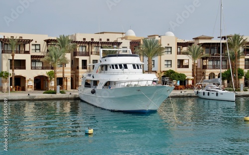 A yacht docks gracefully in front of the house, its sleek design contrasting with the serene surroundings, promising luxurious adventures on the open sea.
