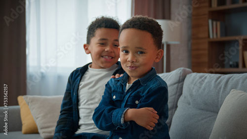 Two funny African American children siblings after quarrel at home funny boy kid pretend offended ignoring joking pretending frustrated sad ignore brother sorry apologize make peace calming friend