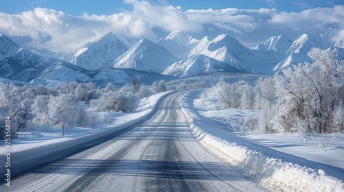 A snowy road with a mountain range in the background