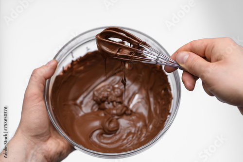 Mieszanie roztopionej czekolady mlecznej w misce na białym tle 