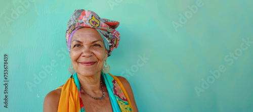 A woman wearing a colorful scarf is smiling. She looks happy and content. Portrait photography of a pleased Brazilian woman in her 70s wearing a foulard against a pastel or soft colors background