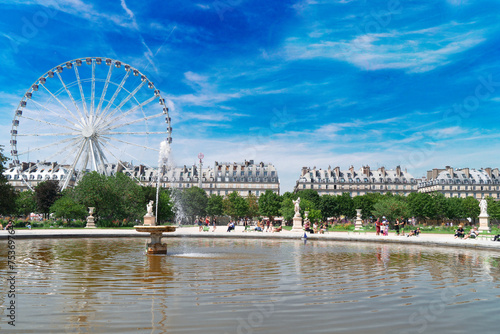 fountain of Tuileries garden with ferry wheel at summer, Paris, France