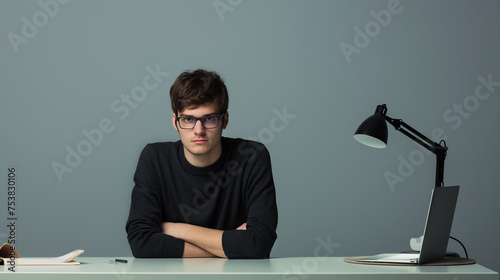 Homem sentado em sua mesa no escritório isoaldo no fundo cinza 