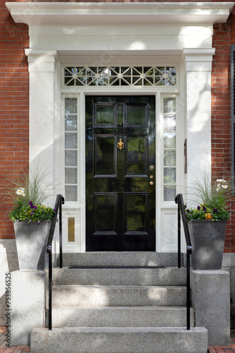 Against the backdrop of New England charm, a black front door exudes timeless sophistication, adding a touch of elegance to the quintessential character of the region.