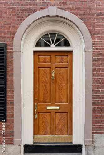 Nestled within a backdrop of rustic red brick, a brown front door exudes warmth and traditional charm, creating a harmonious blend of classic elegance and architectural character.