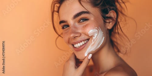 Close up of young woman applying sun cream and touch own face. Skin Protection and dermatology. Girl is smiling. Light background.