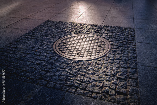 Historic manhole cover used by the insurgents during the Warsaw Uprising on Nowy Swiat Street, Poland