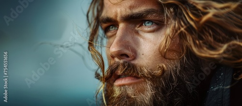 A close-up view of a man featuring long hair and a beard.