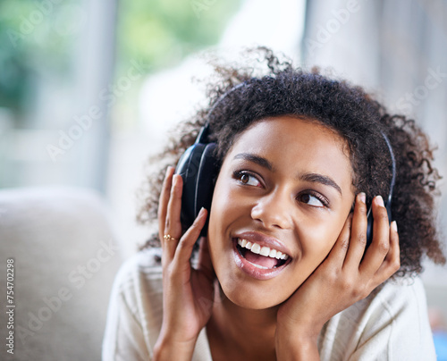 Headphones, smile and happy woman person on couch, living room and listening to music. Happy, joyful or thinking while streaming audio, podcast or radio for entertainment for African female listener