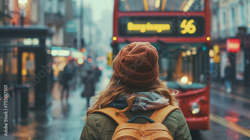 female tourist backpacker looking at 2 storey or double-decker red bus in London, England. Wanderlust concept.