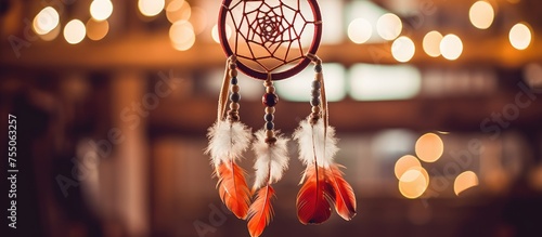 A handmade dream catcher adorned with feathers, threads, and beads is suspended from the ceiling. In the background, soft lights add a warm glow to the scene.