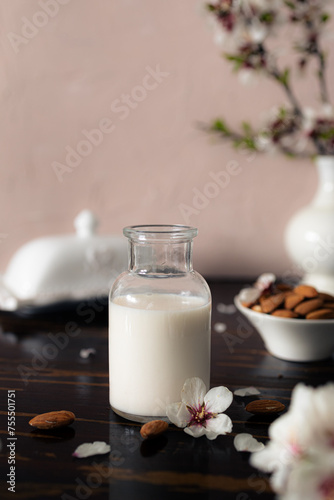 Almond milk with almonds and almond blossoms on the table: the vegan alternative to traditional milk