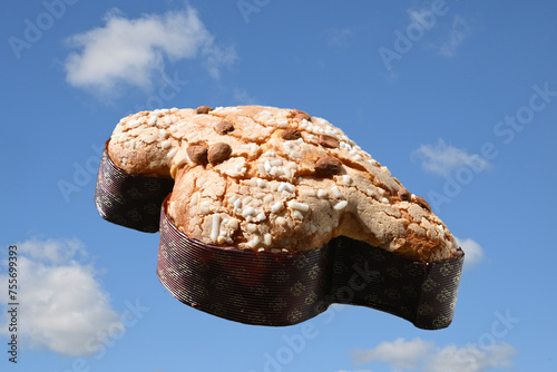 Colomba pasquale on blue sky flying. Easter Dove is a traditional Italian dessert prepared with sourdough, almonds and candied fruit prepared during the Easter holidays. 