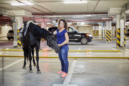Young woman with horse at underground parking