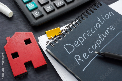 Model of a house and a note depreciation recapture in a notebook.