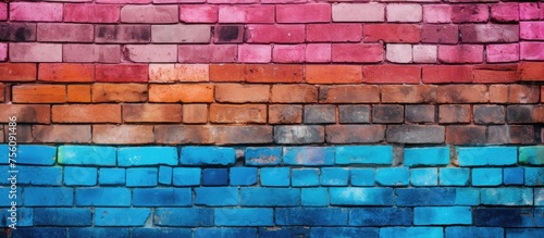 A rectangular brick wall adorned with a vibrant rainbow of colors, creating an artistic pattern of electric blue and symmetry in the brickwork