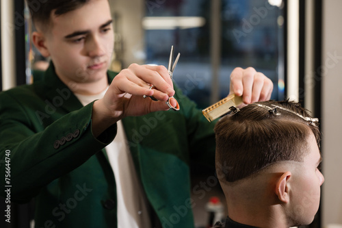 Haircut alignment of the contour of the head with scissors. Short haircut in the barbershop.