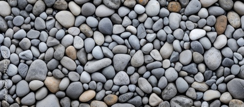 A stack of bedrock rocks creates a unique pattern on the beach resembling a cobblestone road surface, with smaller pebbles and gravel surrounding it
