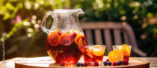 A table set with tableware displaying a pitcher of sangria, two glasses, and fresh orange slices. Sangria is a classic cocktail made with a blend of ingredients like fruit, wine, and other liquids