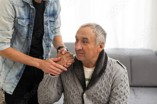 Grown up son asking for apologizes to offended stressed elderly senior daddy, sitting together on couch. Compassionate young man supporting, giving psychological help to frustrated middle aged father.