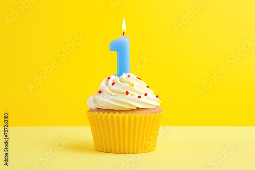 A yellow first birthday cupcake with white icing, a blue number one candle, clean yellow gradient background suitable for a header with room for text. 