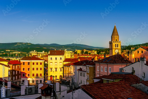 amazing evening town with church, tower with bell , yellow houses and beautiful hills with nice cloudy sky on background, european cityscape of Italy