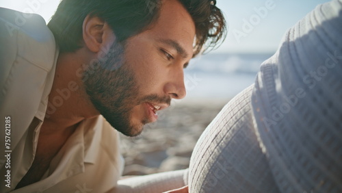 Man talking pregnant tummy woman sitting beach close up. Happy future father 