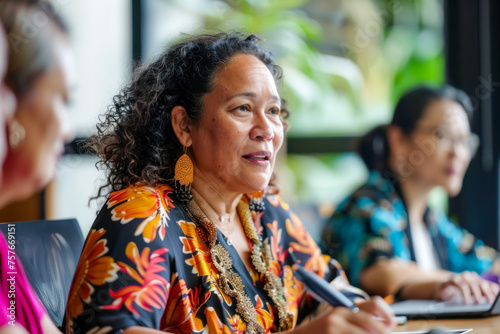 Mature Polynesian woman participating in a discussion at a community meeting with focus and engagement