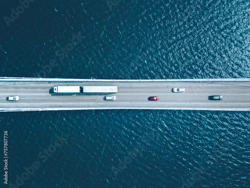 Aerial view of bridge road with cars and truck over lake or sea in Finland