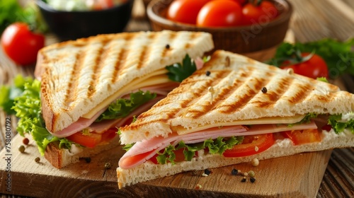 Savory triangle sandwich filled with ham, cheese, ripe tomatoes, and fresh salad greens