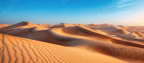 Vast desert landscape with undulating golden sand dunes, clear blue sky & hint of footsteps, symbolizing adventure and tranquility