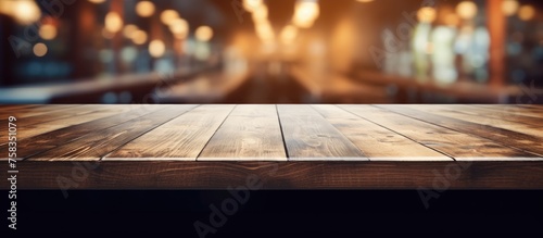 An empty hardwood table on a dark wood floor, with a blurry background of a restaurant. Automotive lighting tints the scene with shades of darkness