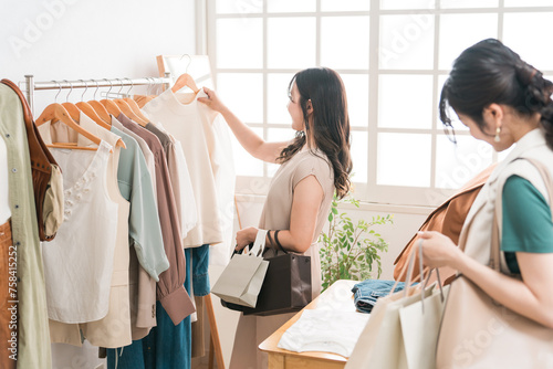 アパレルショップで洋服を買い物・ショッピングする女性とショップ店員 